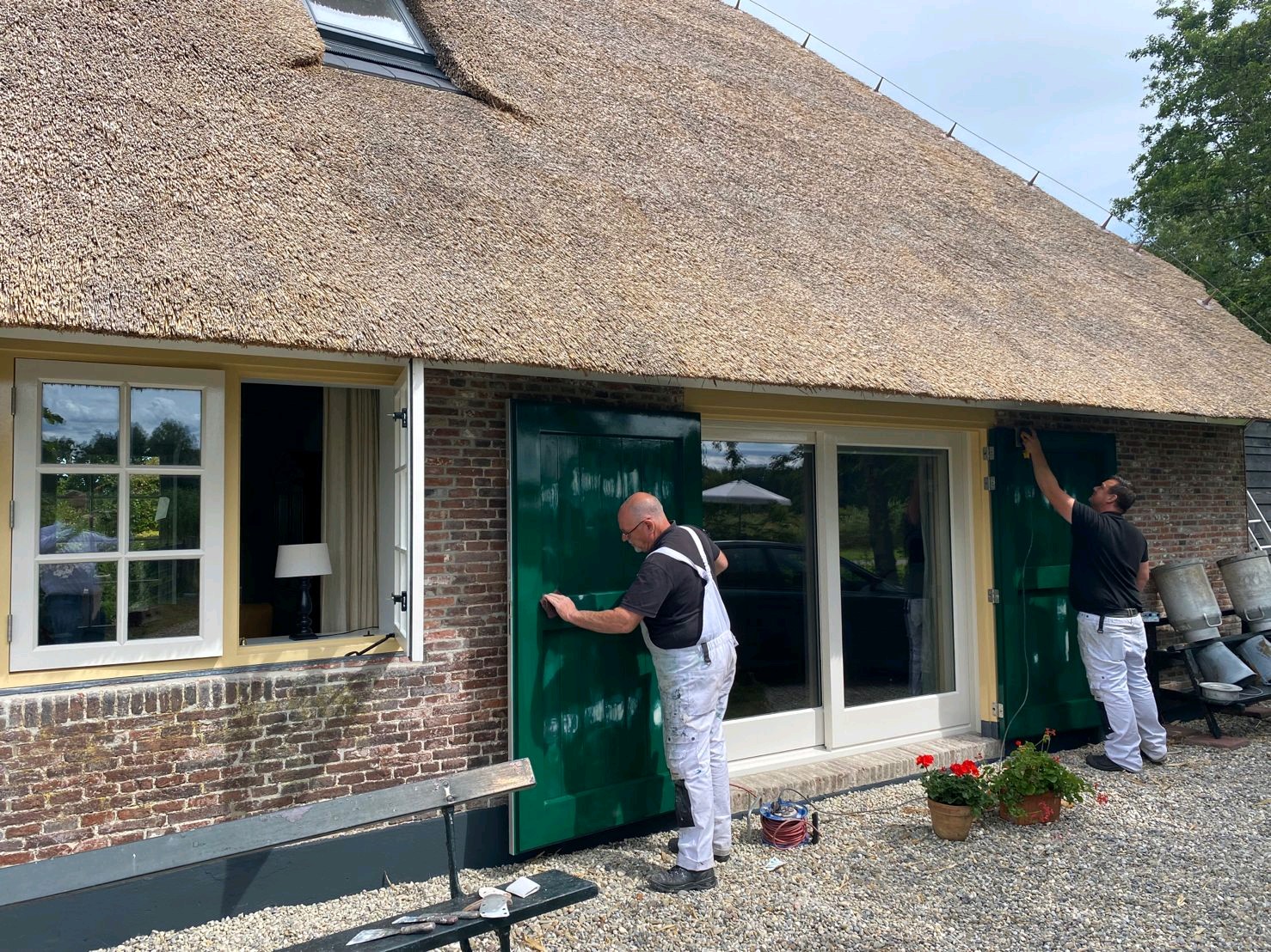 Lee Schilders aan het werk - schilderen van luiken aan rietgedekte boerderij